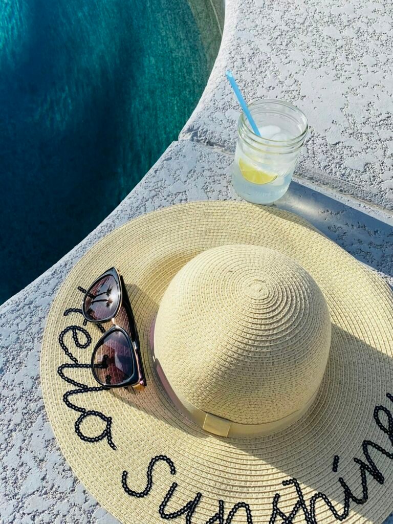 Floppy straw hat with embroidered text and sunglasses