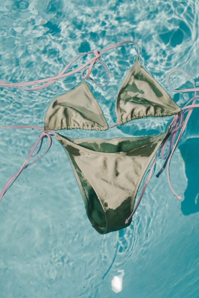 Olive green bikini floating in clear pool water