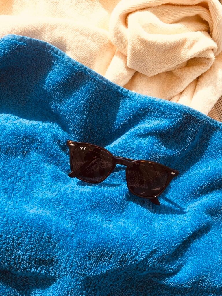 Blue beach towel and sunglasses on the sand