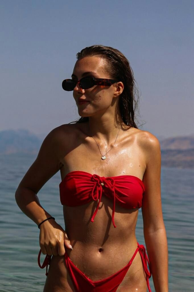Woman in red strapless bikini top by the sea