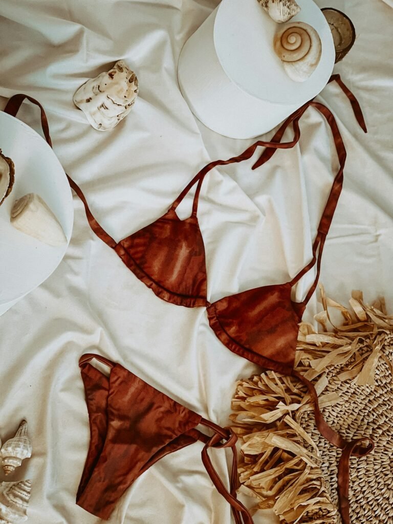 Rust triangle bikini laid out on linen