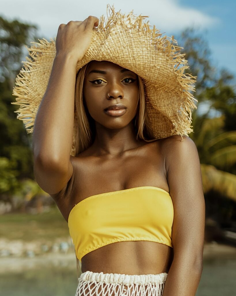 Woman in yellow bandeau top and oversized straw hat