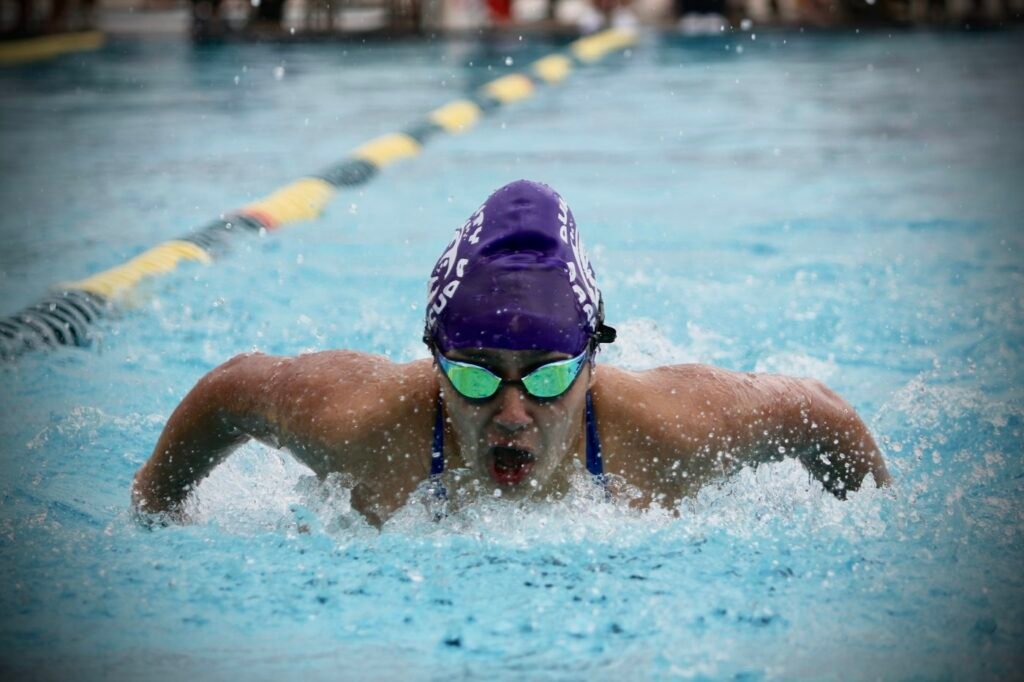 Swimmer with cap and goggles doing butterfly stroke